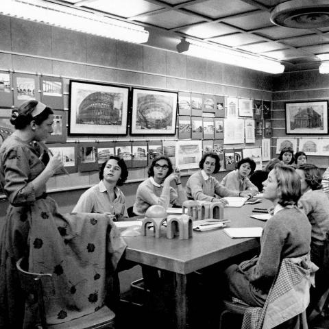 Professor Nochlin speaking to a group of students sitting at a table.