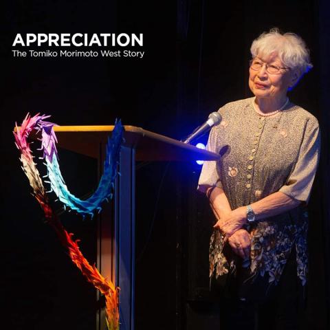 Hiroshima bombing survivor and former Vassar professor Tomiko Morimoto West standing at a lectern on a dark stage with the film title, Appreciation--the Tomiko Morimoto West Story.