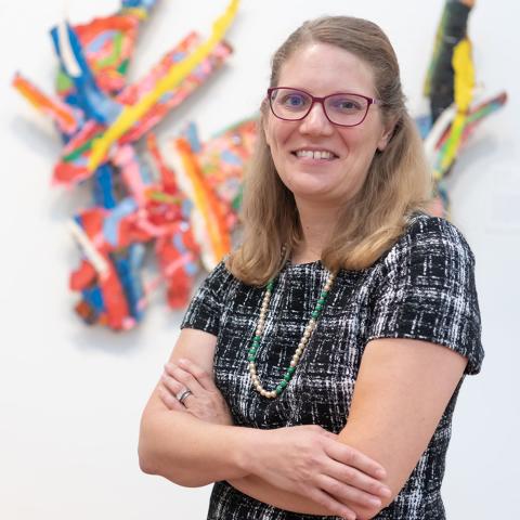 Amanda Potter standing in front of artwork at the Frances Lehman Loeb Art Center
