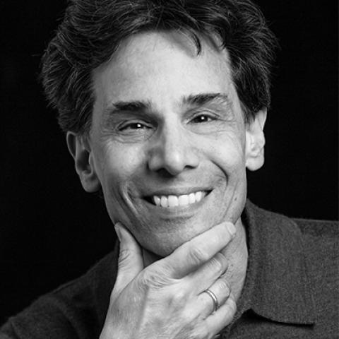 Headshot of Professor Mark Cladis smiling at the camera and resting his chin on his hand.
