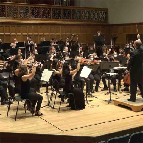 Photo of a conductor and members of an orchestra