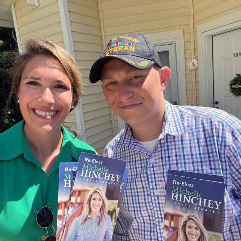 two people holding political pamphlets