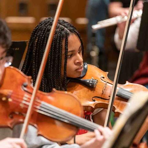 Close-up of a female violinist in an orchestra