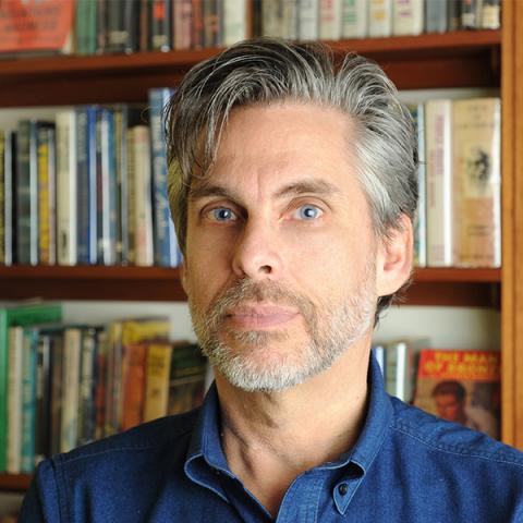 Portrait of Michael Chabon with bookshelves in the background