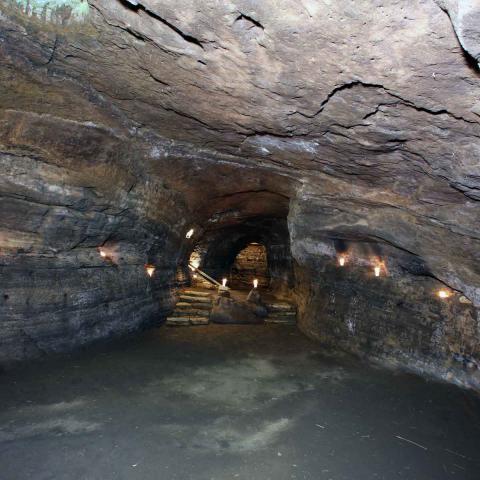 Interior view of a cave with a large opening and lights