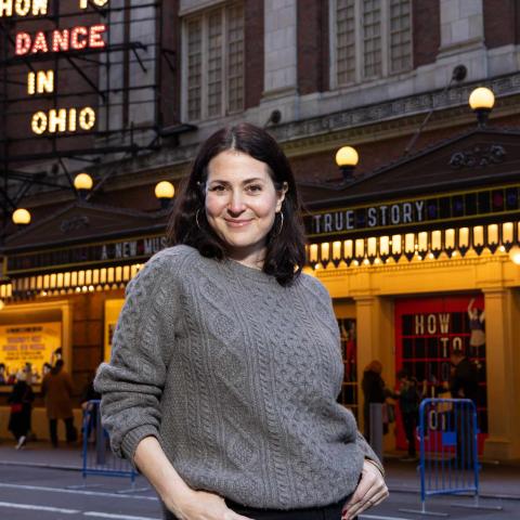 A portrait photo of Alexandra Shiva ’95 in front of the Belasco Theater in Manhattan. 