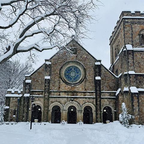 Exterior of the Vassar Chapel building, framed by snow-covered trees and ground.