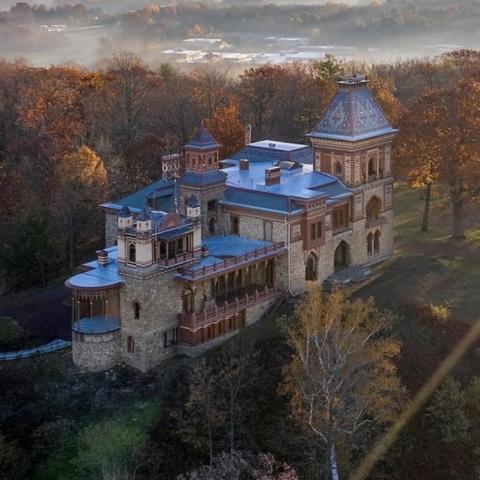 Arial view of the castle style building surrounded by trees.