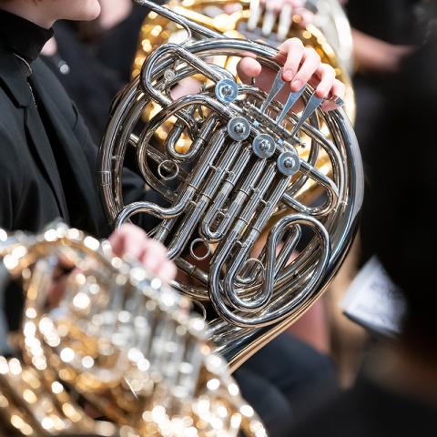Closeup of performer playing French horn