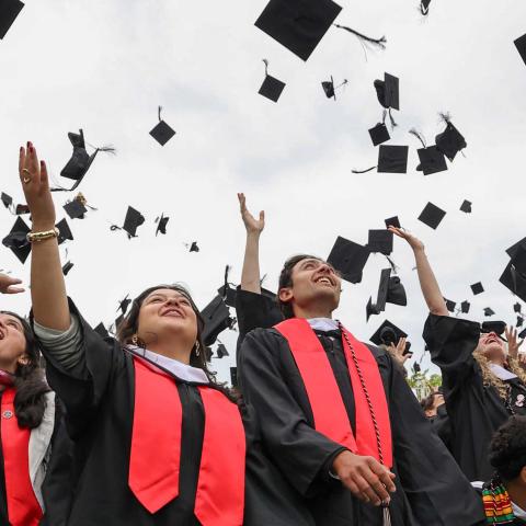 Jubilant graduates throw their mortar boards in the air.