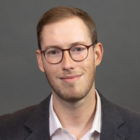 Photo portrait of a person in front of a grey wall.