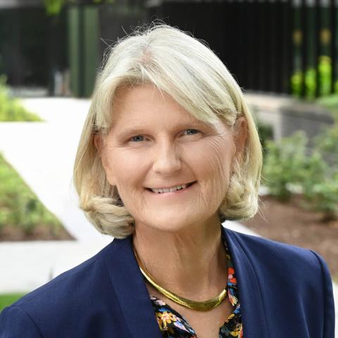 Photo portrait of a person standing in front of a building.