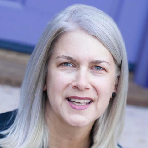 A photo of Lydia Millet, a person with long blond hair and a blue shirt.
