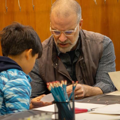 Adult and child work on an art activity