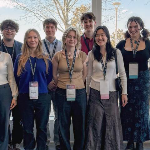 Group of people standing and smiling at a conference.