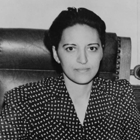 1940s image of a woman sitting at executive desk.