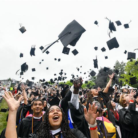 Vassar graduates throw their mortar boards into the air at the 2026 Commencement ceremony.