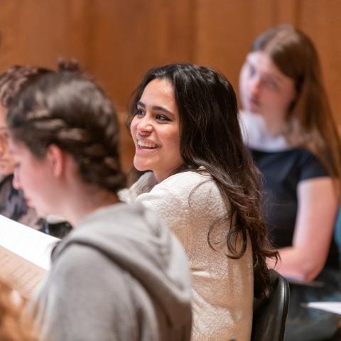 A smiling student rehearses with the Vassar College Chamber Singers.