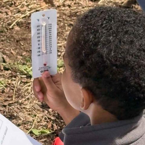 Child reading a thermometer.