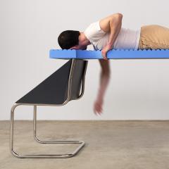 An abstract style of photograph of a person on a platform connected to a metal chair.